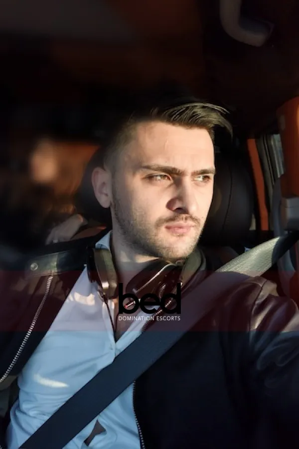 Max sat in a car wearing a suit